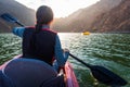 Woman kayaking in Hatta lake in Dubai at sunset