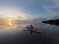 Woman kayaking at sunrise in Bear Cut, Florida.