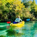 A woman kayaks Down the Weeki Wachee River in Florida