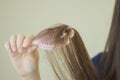 Woman keeping comb with hair in hand. Lots of fallen hair on a comb. Hair loss problem, hormonal failure, stress, diet