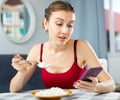 Woman keeping diet, eating rice and texting message