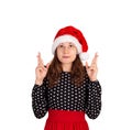 Woman keeps hands raised, fingers crossed and dreams about something. emotional girl in santa claus christmas hat isolated on whit Royalty Free Stock Photo