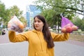 The woman keeps vegetables and fruits in a plastic bag and a cloth shopper.