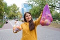 The woman keeps vegetables and fruits in a plastic bag and a cloth shopper.