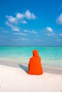 Woman with kerchief sitting on beautiful beach