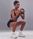 Woman, kettlebell squats and exercise in studio for fitness, sports workout and focus wellness mindset. Strong female