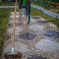 Woman legs washing carpet on grass from hose Royalty Free Stock Photo