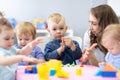 Woman teaches children modeling plasticine in day care center Royalty Free Stock Photo