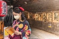 Woman in kimono wearing a mask and reading a guide book of Tokyo.