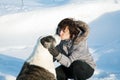 Woman kisses a dog on a sunny winter