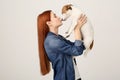 Woman kissing cute Jack Russell Terrier dog on white background. Space for text Royalty Free Stock Photo