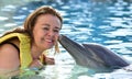 Woman kissing dolphin in pool Royalty Free Stock Photo