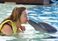 Woman kissing dolphin in pool Royalty Free Stock Photo