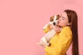 Woman kissing her cute Jack Russell Terrier dog on pink background. Space for text Royalty Free Stock Photo