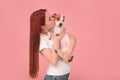 Woman kissing her cute Jack Russell Terrier dog on pink background. Space for text Royalty Free Stock Photo