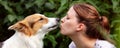 Woman is kissing her cute mixed-breed dog, animal and pet loving