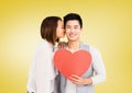 Woman kissing man while holding heart Royalty Free Stock Photo