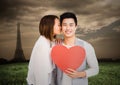 Woman kissing man while holding heart Royalty Free Stock Photo