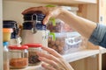 Woman in the kitchen with can of dry mint, food storage, pantry