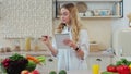 Woman in the kitchen checking a shopping list on a notebook at home. Healthcare concept. Organic fresh fruit and Royalty Free Stock Photo