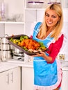 Woman in kitchen is cooking roast meat food in oven. Royalty Free Stock Photo