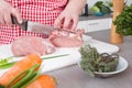 Woman in the kitchen cooking roast pork: cutting meat. Royalty Free Stock Photo