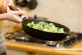 Woman cooking stir fry frozen vegetable on pan