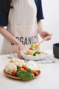 Woman in kitchen cooking stir vegetables on pan and tasting