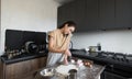 A woman in the kitchen is cooking and talking on the phone. Busy housewife. Royalty Free Stock Photo