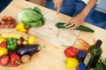 Woman, kitchen and cutting cucumber on wooden board above for healthy diet or vegetables at home. Top view of female Royalty Free Stock Photo