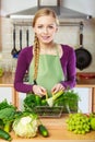 Woman in kitchen having vegetables holding shopping basket Royalty Free Stock Photo