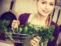 Woman in kitchen having vegetables holding shopping basket Royalty Free Stock Photo