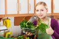 Woman in kitchen having vegetables holding shopping basket Royalty Free Stock Photo