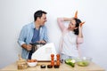 woman in the kitchen making a joke with some carrots in the shape of horns