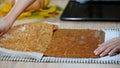 A woman in the kitchen making pumpkin roll. Unstick parchment paper