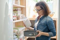 Woman in kitchen pantry. Storage wooden stand with kitchenware, products necessary to cook Royalty Free Stock Photo