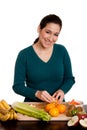 Woman in kitchen peeling orange Royalty Free Stock Photo
