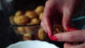 Woman in the kitchen prepares homemade cookies with condensed milk and nuts