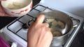 Woman in the kitchen near a gas cooker in a saucepan dumplings for cooking