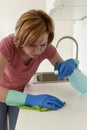 Woman on kitchen with rubber washing gloves cloth and detergent cleaning bored and tired