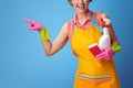 Woman with kitchen sponge and a bottle of detergent pointing at Royalty Free Stock Photo