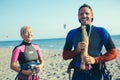 Woman kitesurfer enjoying summertime on sandy beach with her boyfriend. Royalty Free Stock Photo