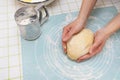 A woman kneads the dough with her hands, the hands of a baker, a silicone mat, a sieve, handmade baking. View from above