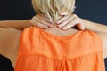 Woman kneads sore neck, back view close up