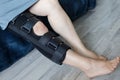 Woman in knee brace support for leg or knee injury at home, leg close up Royalty Free Stock Photo