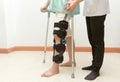 Woman with knee brace in walk training assisted by physiotherapist Royalty Free Stock Photo