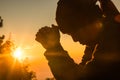 Woman kneeling to pray on Easter Day. Silhouette of prayer woman kneeling and praying over autumn sunset background. Forgive Royalty Free Stock Photo