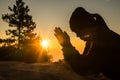 Woman kneeling to pray on Easter Day. Silhouette of prayer woman kneeling and praying over autumn sunset background. Forgive Royalty Free Stock Photo