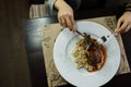 Woman with a knife and fork cuts grilled duck meat. Top view. Hot delicious food. Royalty Free Stock Photo