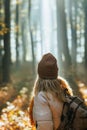 Woman with knit hat and backpack hiking in autumn woodland Royalty Free Stock Photo